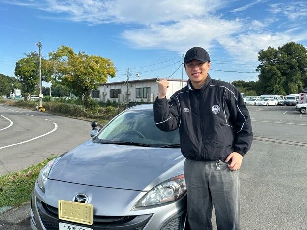 教習車の前でガッツポーズ!「運転、楽しいです」