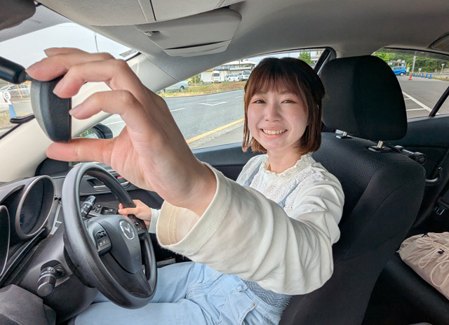 運転席でビッグスマイルの女性のお客様